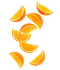 falling fresh orange fruit slices isolated on white background closeup. Flying food concept. Top...