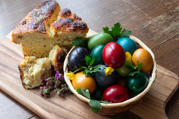 Easter eggs and Easter bun with flowers - wood background