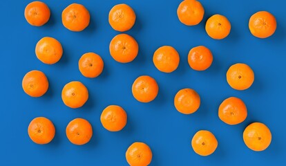 Fruit pattern of fresh orange tangerine or mandarin on blue background. Flat lay, top view. Pop art design, creative summer concept. Citrus in minimal style.