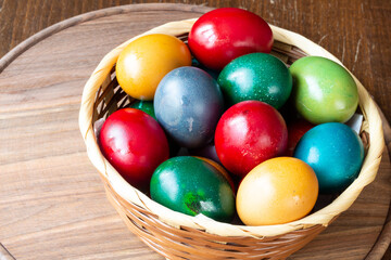 Fototapeta na wymiar Easter eggs and Easter bun with flowers - wood background
