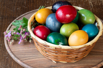 Fototapeta na wymiar Easter eggs and Easter bun with flowers - wood background