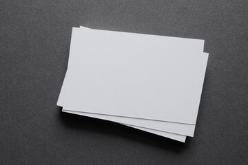 Mock up a stack of blank white cards ün a grey table, space for text or a template