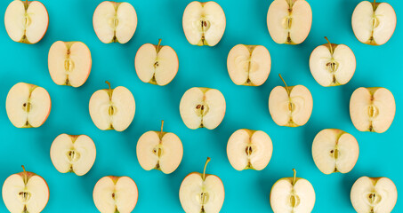 Fruit pattern on blue background. Apple halves geometrical layout. Flat lay, top view. Food...