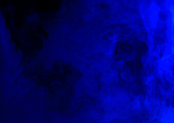 Abstract background of chaotically mixing puffs of blue smoke on a dark background