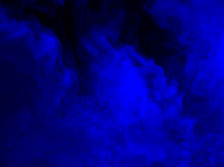 Abstract background of chaotically mixing puffs of blue smoke on a dark background