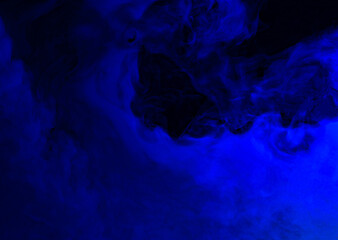 Abstract background of chaotically mixing puffs of blue smoke on a dark background