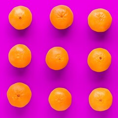 Fruit pattern of fresh orange tangerine or mandarin on lilac background. Flat lay, top view. Pop art design, creative summer concept. Citrus in minimal style.