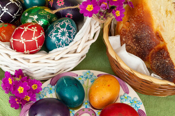 Easter eggs and Easter bun with flowers - green background