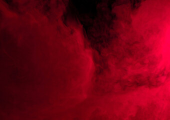 Abstract background of chaotically mixing puffs of red smoke on a dark background