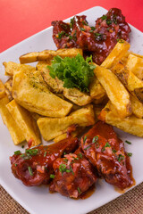 Comida gastronómica de pollo y papas nativas fritas en plato para restaurante, alitas a la barbacoa