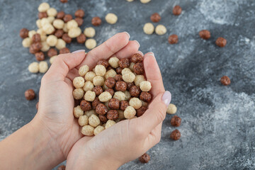 Female hands holding white and brown sweet corn balls