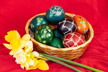 Easter eggs and Easter bun with flowers - red background