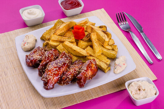 Comida gastron&oacute;mica de pollo y papas nativas fritas en plato para restaurante