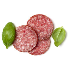 Slices of salami isolated on white background closeup. Sausage and basil leaves top view.