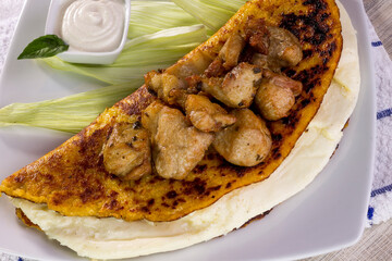 Comida típica de Venezuela servido en plato para restaurante, cachapas con relleno de queso jamón, cochino frito