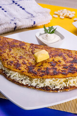 Comida típica de Venezuela servido en plato para restaurante, cachapas con relleno de queso jamón, cochino frito