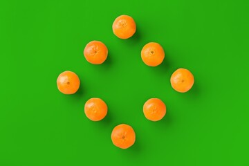 Fruit pattern of fresh orange tangerine or mandarin on green background. Flat lay, top view. Pop art design, creative summer concept. Citrus in minimal style.