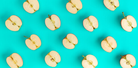 Fruit pattern on blue background. Apple halves geometrical layout. Flat lay, top view. Food background. .  Pop art design, creative summer concept.