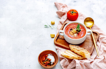 Fresh Cold tomato soup with bread on table. Summer food. Top view, copy space