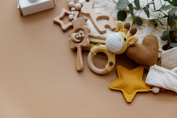 Newborn baby accessory and wooden toys in a box on a brown background. Top view, flat lay. Baby shower. Newborn stuff - 414808664