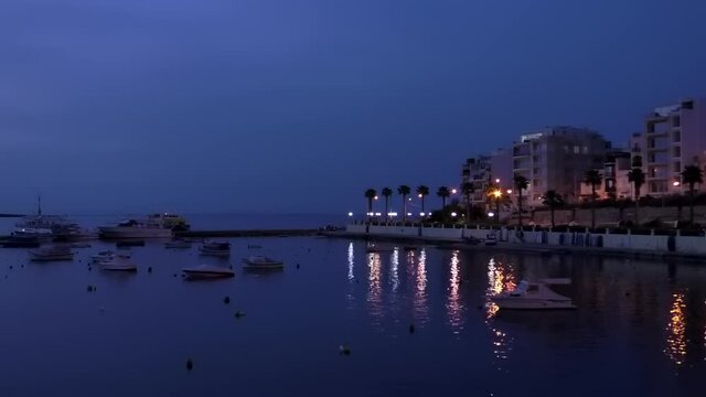 Boats resting in Malta Buggiba Bay marina at night.