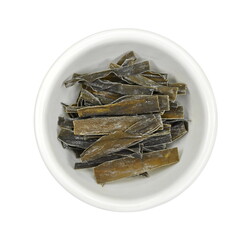 Dried kombu seaweed in a white bowl. Dried kombu seaweed Japanese dry kelp isolated on white background.