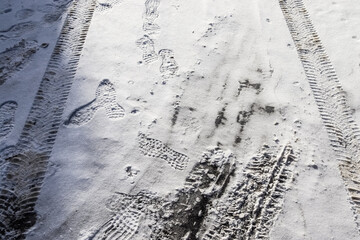 Tire Tracks on snow covered streets in a close up view.