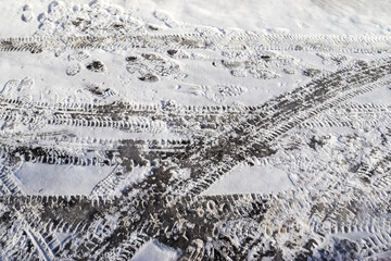Tire Tracks on snow covered streets in a close up view.