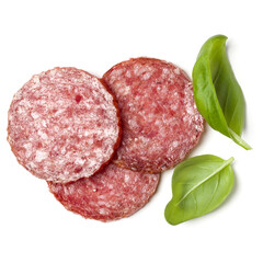 Slices of salami isolated over white background closeup. Sausage and basil leaves top view..