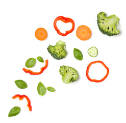 Creative layout made of tomato slice, cucumber, basil leaves. Flat lay, top view. Food concept. Vegetables isolated on white background. Food ingredients pattern.