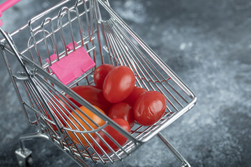 Fresh red tomatoes in small shopping cart