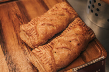 Puff pastry with toppings. Puffs with cheese on a wooden tray. Pastries and bakery, top view.
