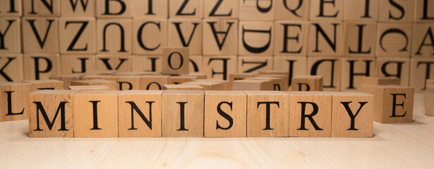 The word ministry is from wooden cubes. Economy state government terms. Closeup.