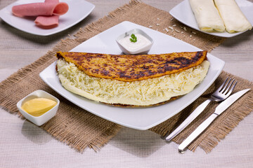 Comida típica de Venezuela servido en plato para restaurante, cachapas con relleno de queso jamón, cochino frito