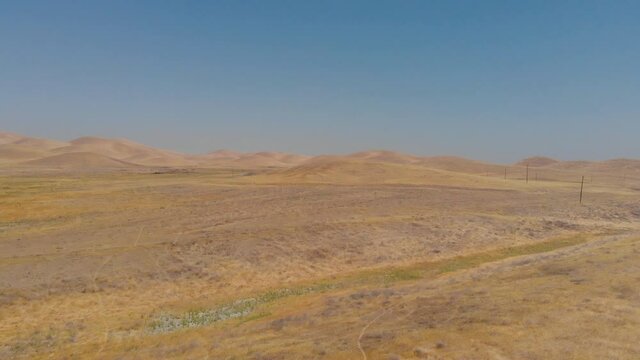 Dolly Forward in the golden desert on a clea sky day in the warmth