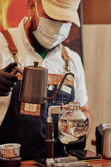 Fototapeta na wymiar hombre con tapaboca exponiendo un metodo de preparacion de cafe