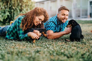 Young nice looking couple wants to adopt beautiful dog at animal shelter.