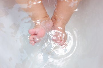 baby feet in a white bathtub
