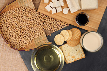 Soyabeans products soya beans flowing bamboo sieve wooden board on jute black stone slate...