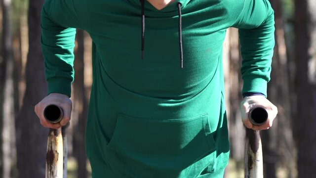 Man working out on the parallel bars in the forest. Healthy lifestyle