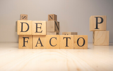 The Defacto Word is from wooden cubes. Terms of state government.