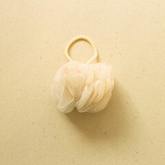 Shower ball. Puff Shower sponge on beige background. Bathroom. top view