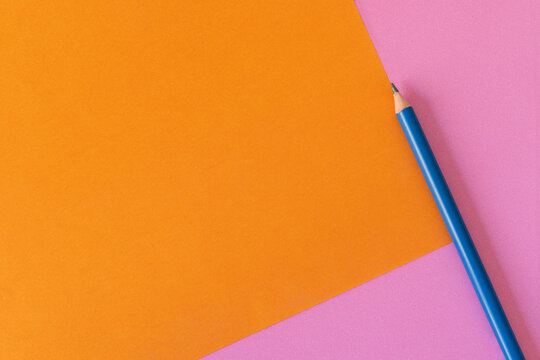 Fondo colorido naranja y rosa, minimalista, con lápiz azul 