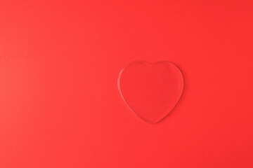 A large transparent heart on a bright red background.