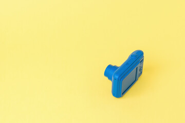 A small camera on a light yellow background.