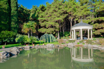 White gazebo in the park near the lake.