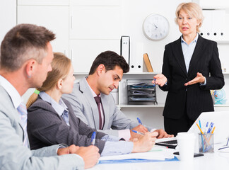 Fototapeta premium Successful business woman holding meeting with colleagues in office