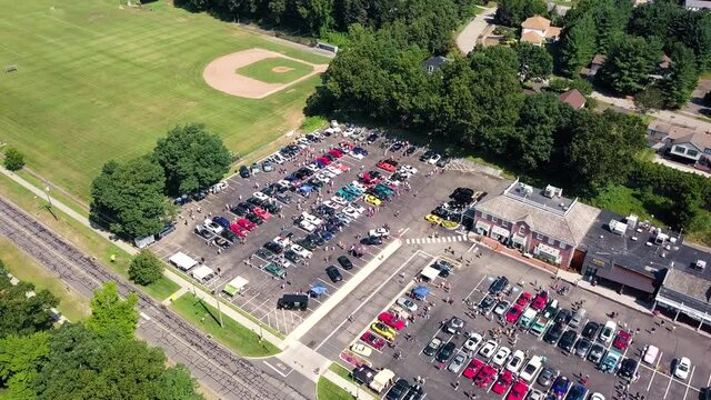 Aerial view around parking lots full of old, vintage and sport cars, sunny day - circling drone shot