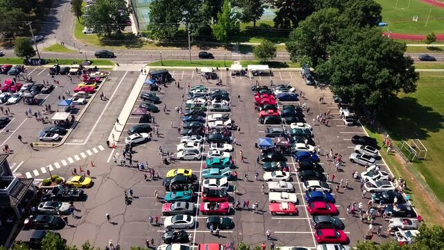 Aerial view over a parking lot full of old, vintage and sport cars, sunny day