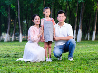 Happy family of three playing in the park